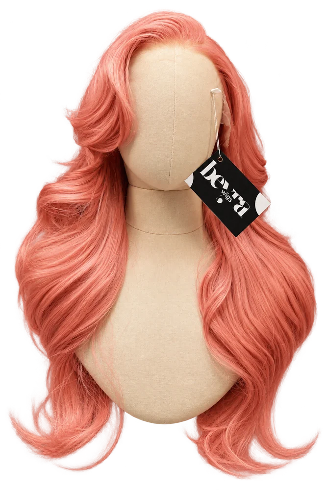 Front view of a coral pink wavy wig on a beige mannequin